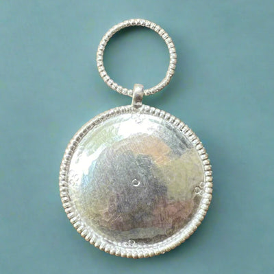 Silver Oval Pendant with large hoop on top. It is known as Melong wisdom mirror in Buddhist ritual practice